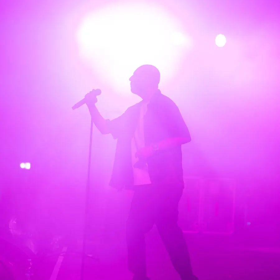 Singer silhouetted in pink stage light